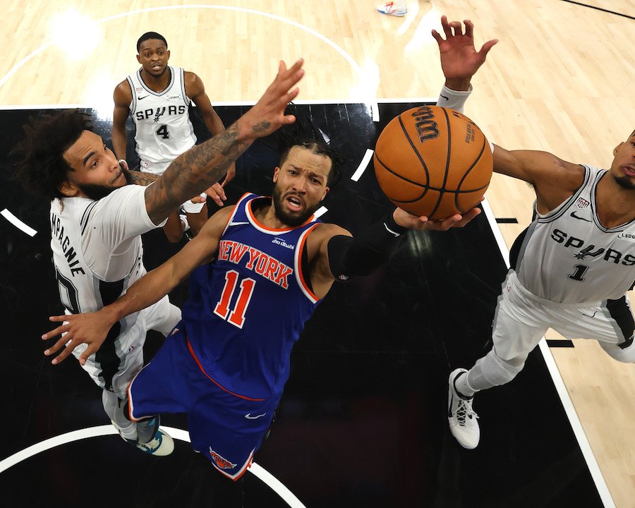 Jalen Brunson of the New York Knicks shoots the ball between Julian Champagnie and Victor Wembanyama of the San Antonio Spurs during the 2026 NBA Finals