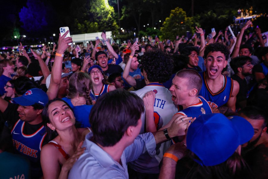 Fans celebrate the New York Knicks winning the 2026 NBA championship on the streets of New York City.