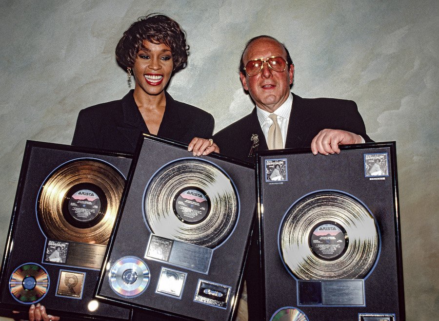 Whitney Houston and Clive Davis showing off plaques commemorating sales of her 1990 album 'I'm Your Baby Tonight'