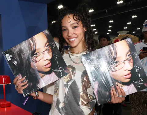 Singer Tinashe holds up copies of her album 'Popstar' at the ComplexCon 2026 10-Year Anniversary Festival