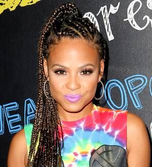 Christina Milian poses closely with a man in an open-air restaurant