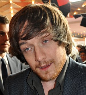 James McAvoy in a light-colored suit and dark tie, looking slightly to the side