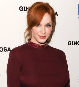Christina Hendricks smiles wearing a black and white patterned dress