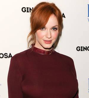 Christina Hendricks smiles wearing a black and white patterned dress