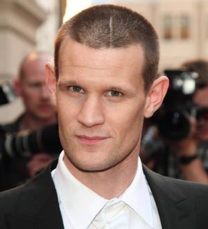 Matt Smith poses with an intense expression, looking left, against a blurred background