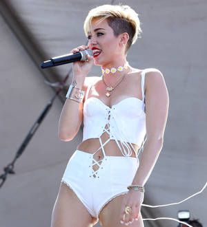 Miley Cyrus goes topless and gets tattooed for magazine