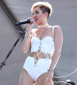 Miley Cyrus goes topless and gets tattooed for magazine