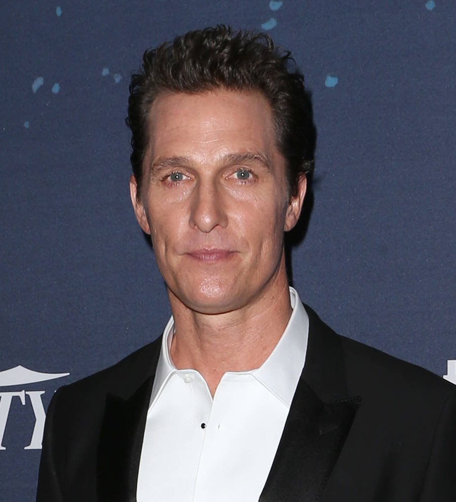 Matthew McConaughey with a microphone on a stage, speaking at an event or conference