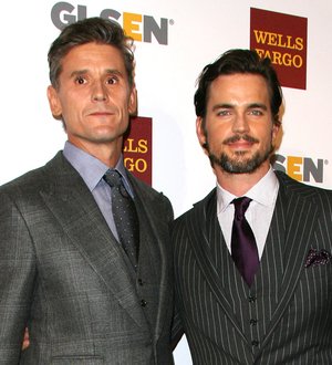 Matt Bomer smiles, accepting an LGBT award onstage, holding a microphone
