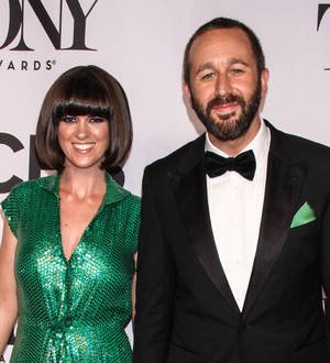 Chris O'Dowd sits with a newborn baby resting on his chest, looking down at the child