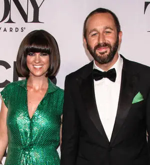 Chris O'Dowd sits with a newborn baby resting on his chest, looking down at the child