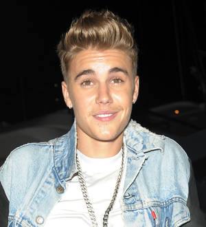 Justin Bieber rides Vespa while using cell phone