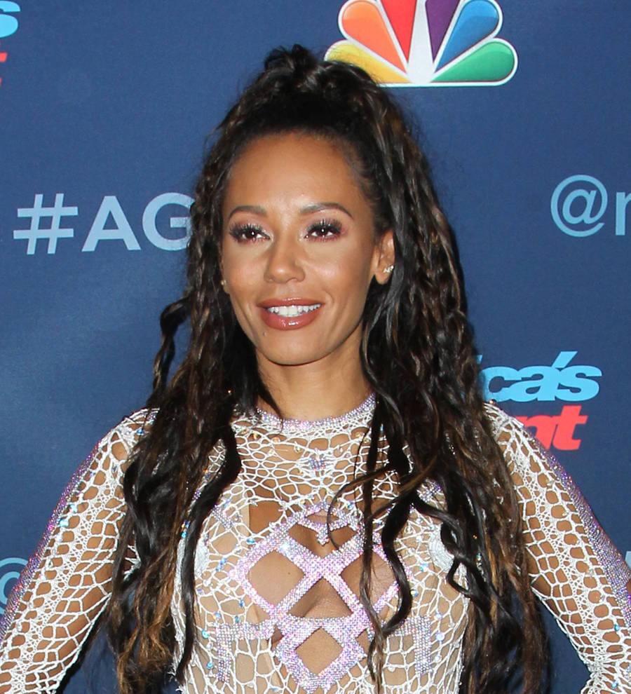 Mel B in a black and white close-up, gazing seriously at the camera with her hand to her chin